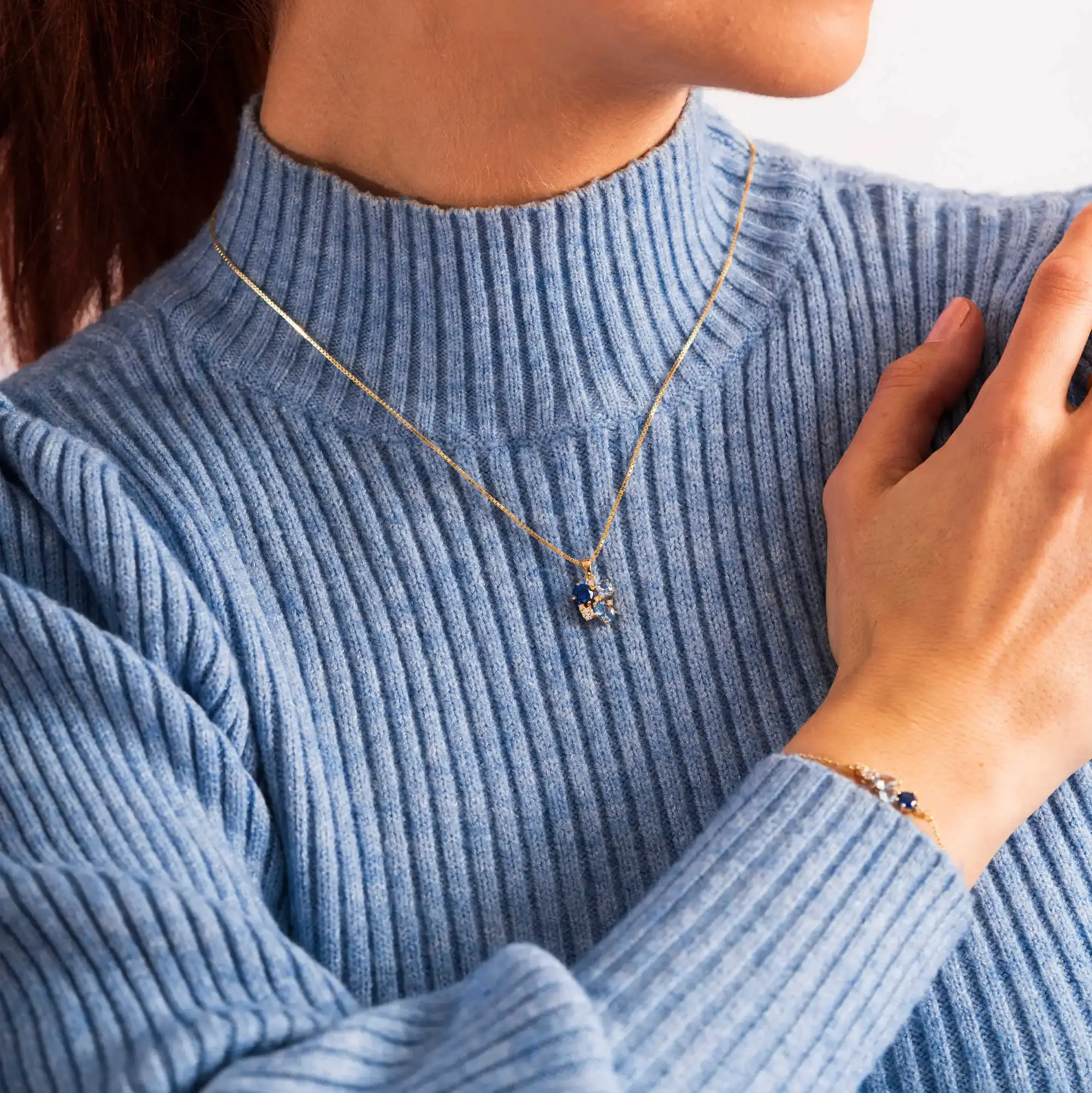 Elegant anheng i forgylt sølv med blå zirkonia.